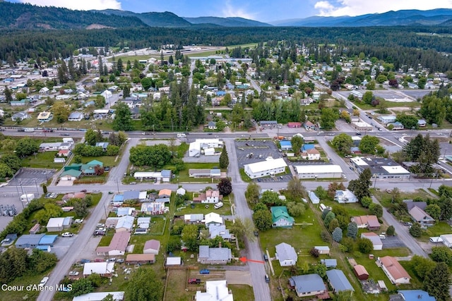 112 Washington St, Priest River, ID 83856 - aerial overview of property's location featuring a mountain backdrop, a heavily wooded area, and nearby suburban area