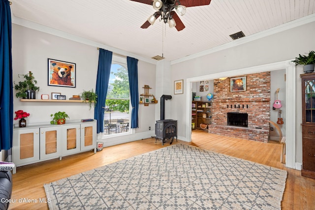 15152 N Mill St, Rathdrum, ID 83858 - living room featuring ceiling fan, wood finished floors, a wood stove, crown molding, and a fireplace