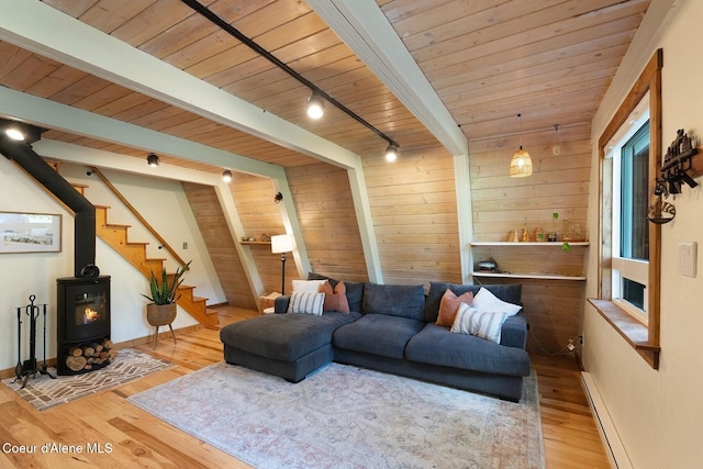 11 Hackney Ln, Sandpoint, ID 83864 - living room with wooden ceiling with exposed beams, wood finished floors, a wood stove, wood walls, and track lighting