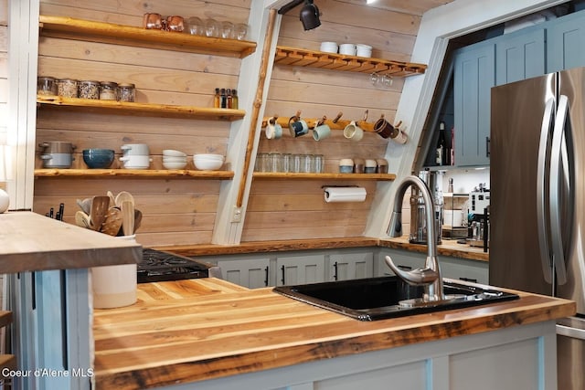 11 Hackney Ln, Sandpoint, ID 83864 - kitchen with wooden counters, freestanding refrigerator, open shelves, a sink, and wood walls