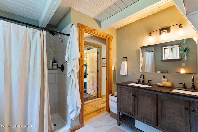 11 Hackney Ln, Sandpoint, ID 83864 - full bathroom with double vanity, a shower with shower curtain, marble look tiles, and wooden ceiling with exposed beams