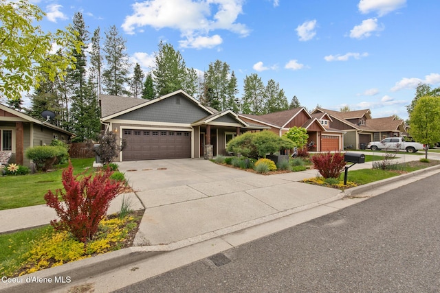 305 Maddie Ln, Sandpoint, ID 83864 - craftsman-style home featuring an attached garage, driveway, a front lawn, and stone siding