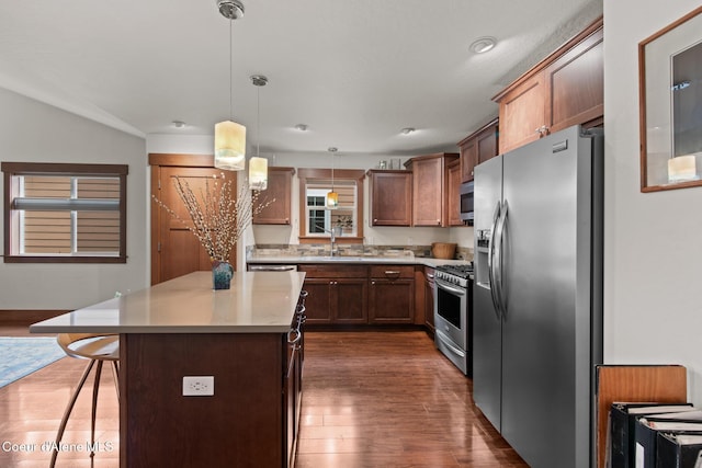 305 Maddie Ln, Sandpoint, ID 83864 - kitchen with appliances with stainless steel finishes, a breakfast bar, dark wood-style floors, hanging light fixtures, and a center island