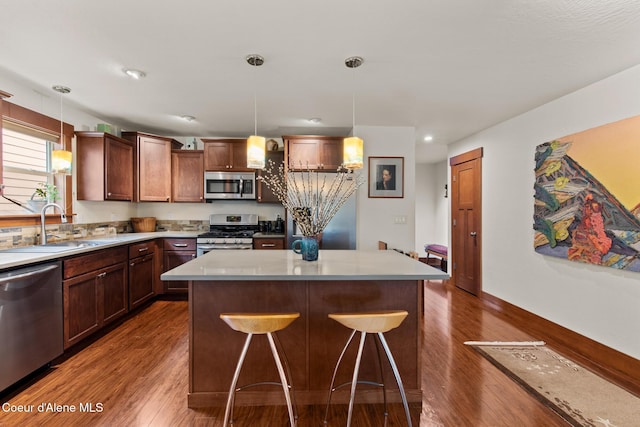 305 Maddie Ln, Sandpoint, ID 83864 - kitchen featuring stainless steel appliances, a sink, dark wood finished floors, a breakfast bar area, and light countertops