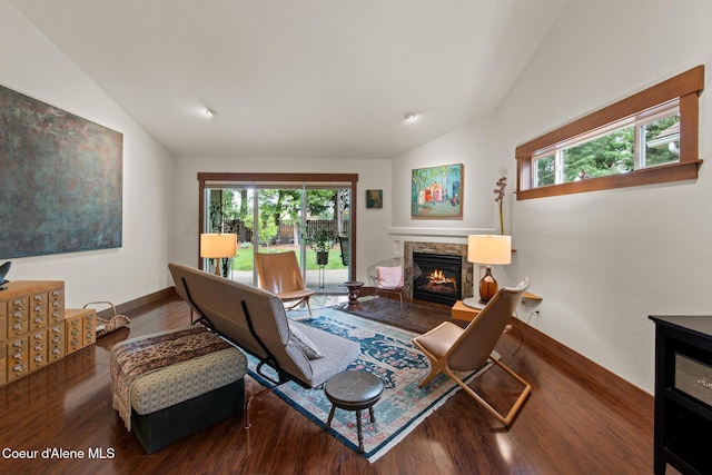 305 Maddie Ln, Sandpoint, ID 83864 - living room featuring vaulted ceiling, wood finished floors, a stone fireplace, and healthy amount of natural light