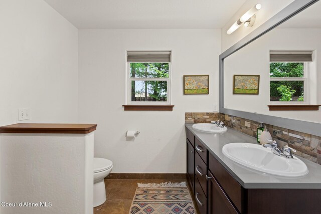 305 Maddie Ln, Sandpoint, ID 83864 - bathroom with baseboards, double vanity, plenty of natural light, and tasteful backsplash