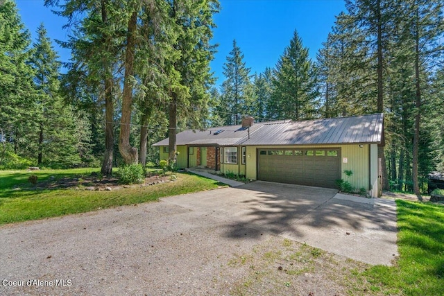 12696 N Dover Ln, Hayden, ID 83835 - view of front facade featuring driveway, a garage, a chimney, and metal roof
