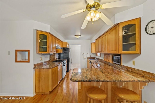 12696 N Dover Ln, Hayden, ID 83835 - kitchen featuring gas range, under cabinet range hood, a kitchen breakfast bar, a peninsula, and ceiling fan