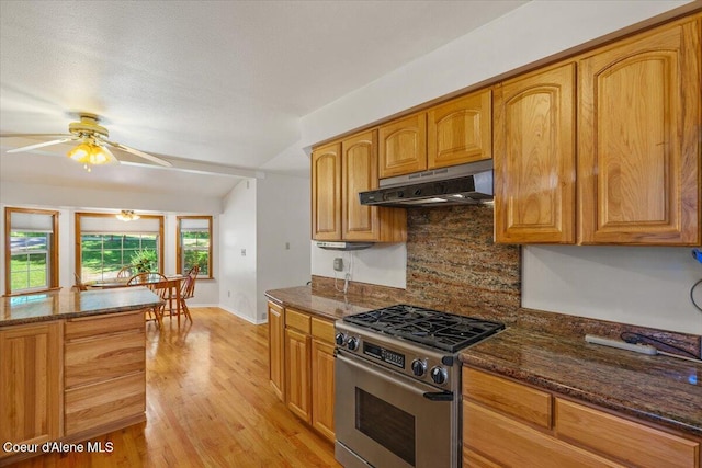 12696 N Dover Ln, Hayden, ID 83835 - kitchen with gas range, under cabinet range hood, tasteful backsplash, and dark stone countertops
