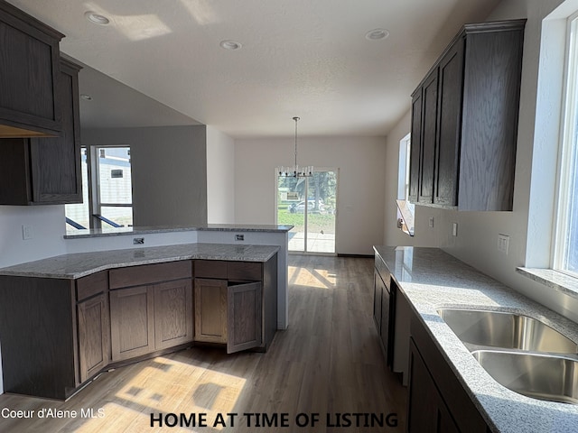 4531 E Davin Dr, Post Falls, ID 83854 - kitchen with light wood-style flooring, a peninsula, a chandelier, hanging light fixtures, and light stone countertops