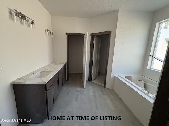 4531 E Davin Dr, Post Falls, ID 83854 - full bath with wood finished floors, a garden tub, double vanity, and a textured ceiling