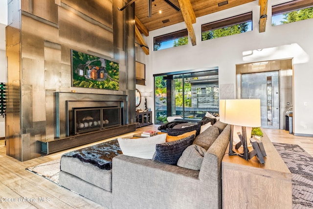 6361 S Cormorant Ct, Harrison, ID 83833 - living area with a high ceiling, wood finished floors, a fireplace with raised hearth, and beamed ceiling