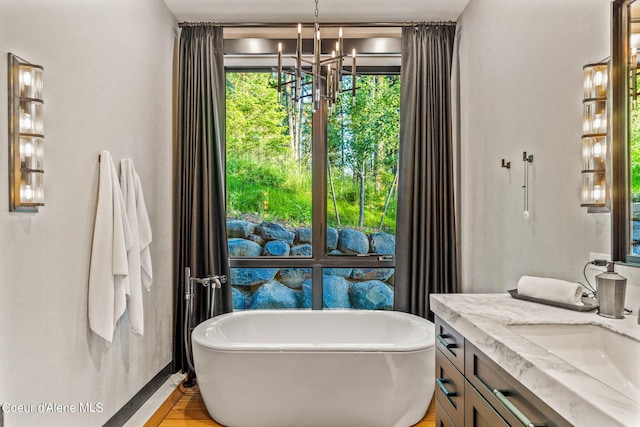 6361 S Cormorant Ct, Harrison, ID 83833 - full bathroom featuring vanity, a chandelier, a soaking tub, and wood finished floors