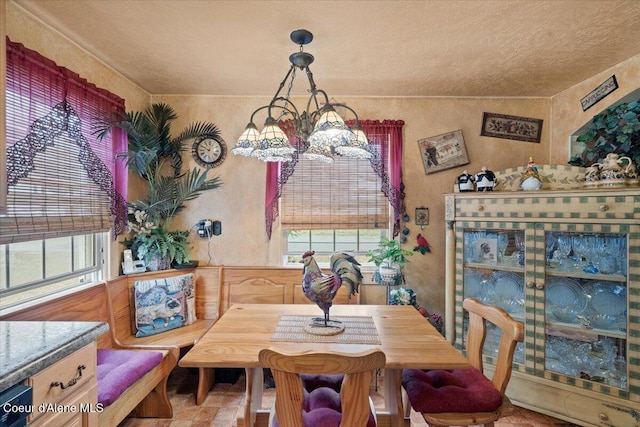 301 Third St, Osburn, ID 83849 - dining room featuring healthy amount of natural light, a textured ceiling, a textured wall, and a chandelier