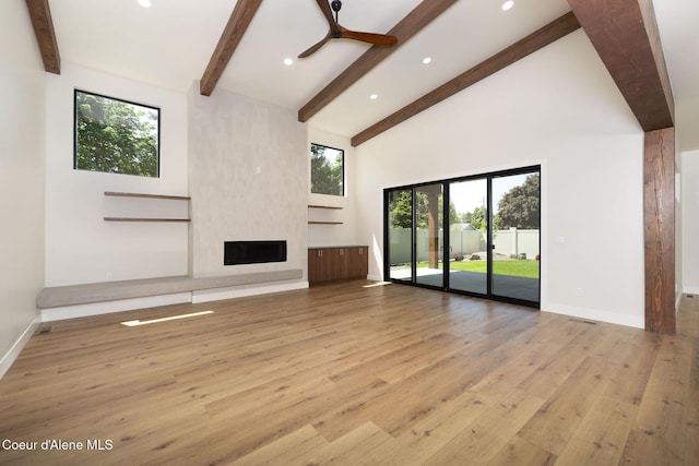 1456 E Ezra Ave, Hayden, ID 83835 - unfurnished living room featuring hardwood / wood-style floors, beam ceiling, high vaulted ceiling, a large fireplace, and recessed lighting
