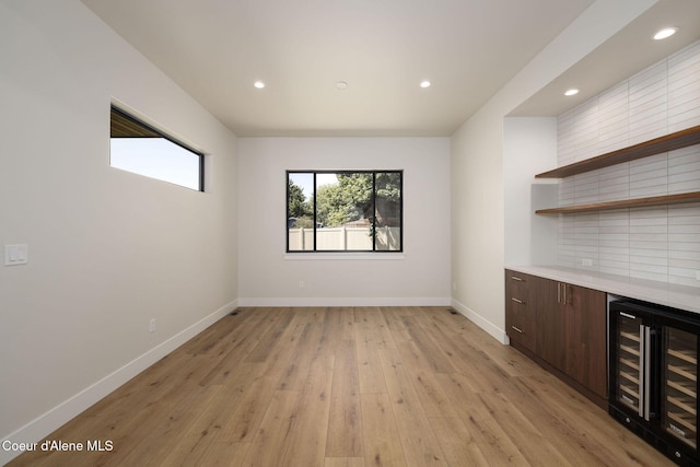 1456 E Ezra Ave, Hayden, ID 83835 - indoor dry bar with wine cooler, baseboards, light wood finished floors, and recessed lighting