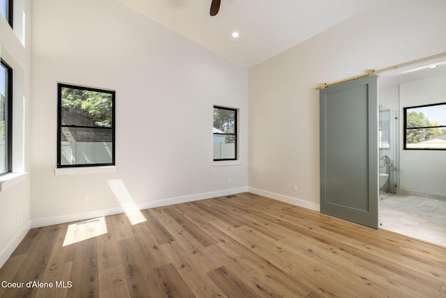 1456 E Ezra Ave, Hayden, ID 83835 - unfurnished bedroom featuring multiple windows, light wood finished floors, high vaulted ceiling, baseboards, and recessed lighting