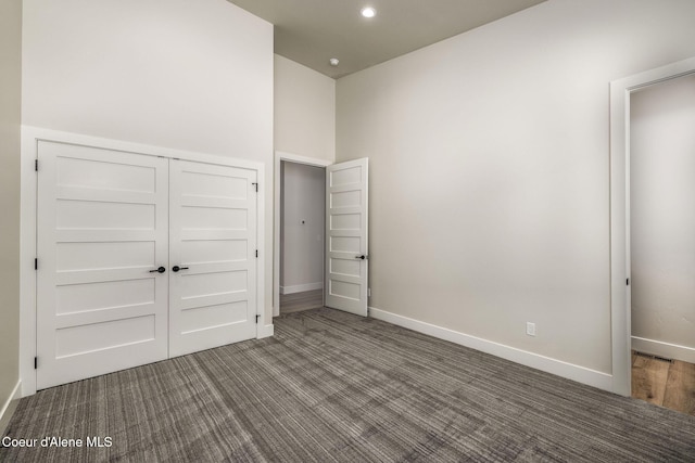 1456 E Ezra Ave, Hayden, ID 83835 - unfurnished bedroom featuring baseboards, dark colored carpet, and a closet