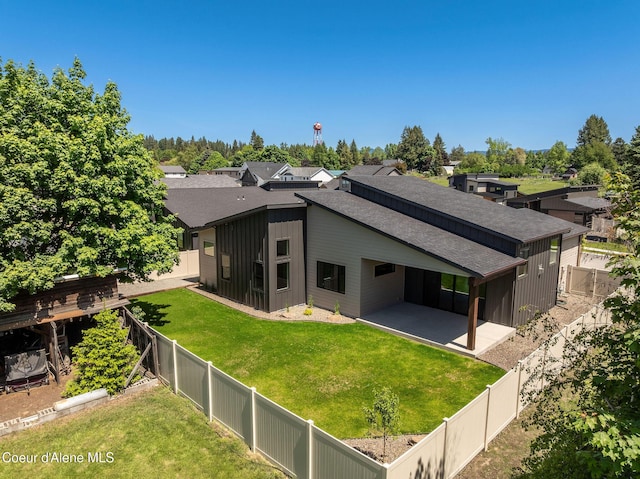 1456 E Ezra Ave, Hayden, ID 83835 - back of house with a patio, roof with shingles, and board and batten siding