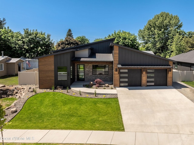 1456 E Ezra Ave, Hayden, ID 83835 - view of front of home featuring a garage, concrete driveway, a standing seam roof, and board and batten siding