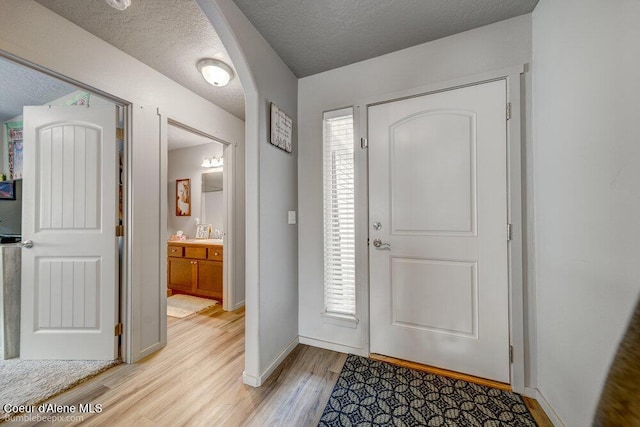 7156 W Christine St, Rathdrum, ID 83858 - foyer entrance featuring light wood-style flooring, baseboards, and a textured ceiling
