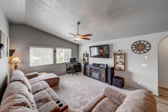 7156 W Christine St, Rathdrum, ID 83858 - living area with vaulted ceiling, a textured ceiling, ceiling fan, a desk, and arched walkways