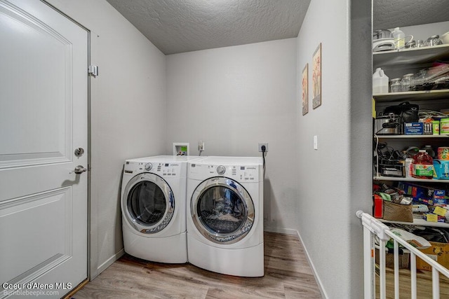7156 W Christine St, Rathdrum, ID 83858 - washroom featuring washer and dryer, wood finished floors, a textured ceiling, and baseboards