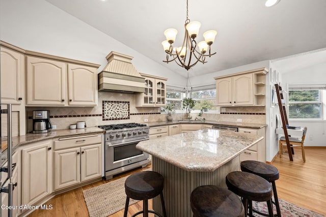 3061 E Lake Forest Dr, Hayden Lake, ID 83835 - kitchen featuring stainless steel appliances, lofted ceiling, custom range hood, a breakfast bar area, and a chandelier