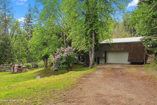 272 Hidden Springs Rd, Sandpoint, ID 83864 - view of front of property with driveway, an attached garage, an outbuilding, and metal roof