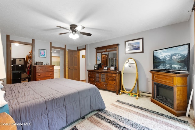 272 Hidden Springs Rd, Sandpoint, ID 83864 - bedroom featuring carpet, a glass covered fireplace, ceiling fan, and connected bathroom