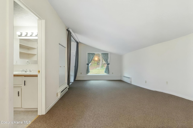 272 Hidden Springs Rd, Sandpoint, ID 83864 - unfurnished living room featuring lofted ceiling, light colored carpet, a baseboard radiator, baseboards, and a sink