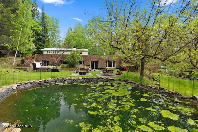 272 Hidden Springs Rd, Sandpoint, ID 83864 - back of house featuring a patio, a small pond, and brick siding