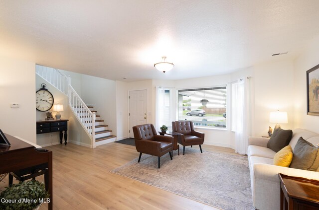 9105 N Prescott Dr, Hayden, ID 83835 - living room featuring stairs, light wood-style floors, and baseboards