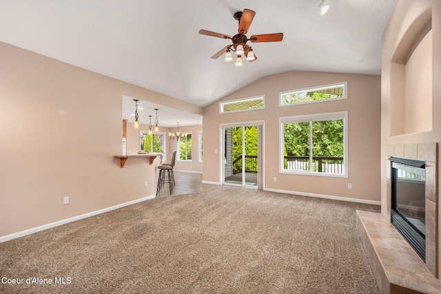 10016 N Zack Ct, Hayden, ID 83835 - unfurnished living room with a tiled fireplace, carpet flooring, lofted ceiling, ceiling fan, and a chandelier