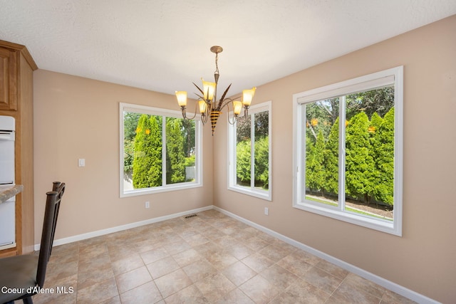 10016 N Zack Ct, Hayden, ID 83835 - unfurnished dining area with a chandelier and baseboards