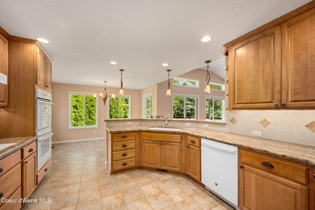 10016 N Zack Ct, Hayden, ID 83835 - kitchen with white appliances, a peninsula, pendant lighting, recessed lighting, and a chandelier