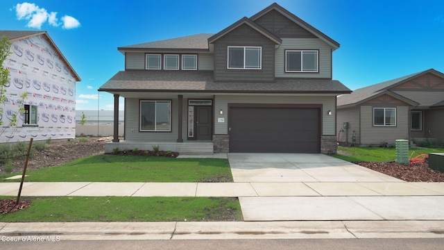 6354 Astoria Loop, Rathdrum, ID 83858 - view of front of property with a garage, concrete driveway, roof with shingles, a front lawn, and covered porch