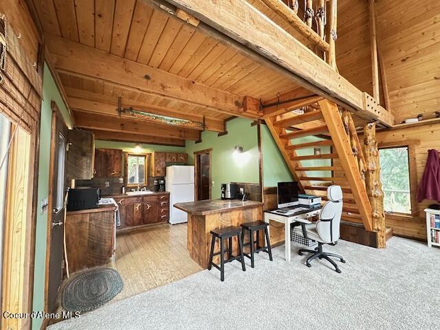 474 NW Fork Santa Creek Rd, Emida, ID 83861 - office space featuring wooden ceiling with exposed beams, light carpet, wood walls, and a sink