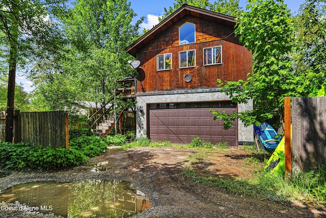 913 Cedar St, Sandpoint, ID 83864 - view of front facade with an attached garage, stairway, and driveway