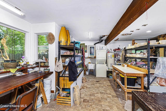 913 Cedar St, Sandpoint, ID 83864 - basement featuring electric water heater, a workshop area, stacked washer / drying machine, and stone finish floors