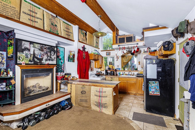 913 Cedar St, Sandpoint, ID 83864 - kitchen featuring freestanding refrigerator, brown cabinets, a peninsula, a glass covered fireplace, and a sink