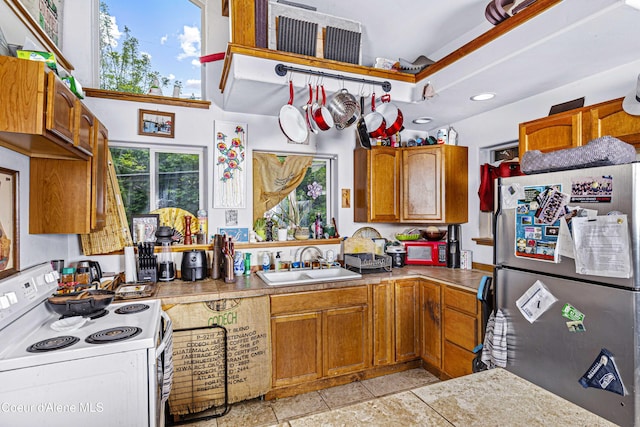 913 Cedar St, Sandpoint, ID 83864 - kitchen featuring freestanding refrigerator, white range with electric cooktop, a sink, brown cabinets, and recessed lighting