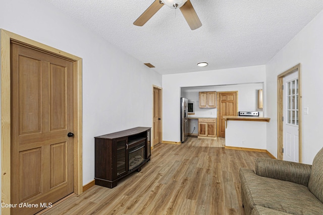913 Cedar St, Sandpoint, ID 83864 - living room with ceiling fan, a textured ceiling, light wood-type flooring, and baseboards