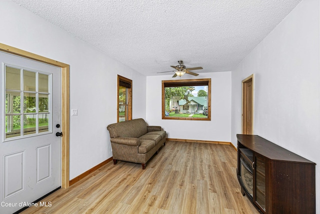 913 Cedar St, Sandpoint, ID 83864 - living area with a textured ceiling, light wood finished floors, baseboards, and a ceiling fan