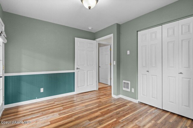 31716 N Middle Ave, Spirit Lake, ID 83869 - unfurnished bedroom featuring wood finished floors, baseboards, and a closet