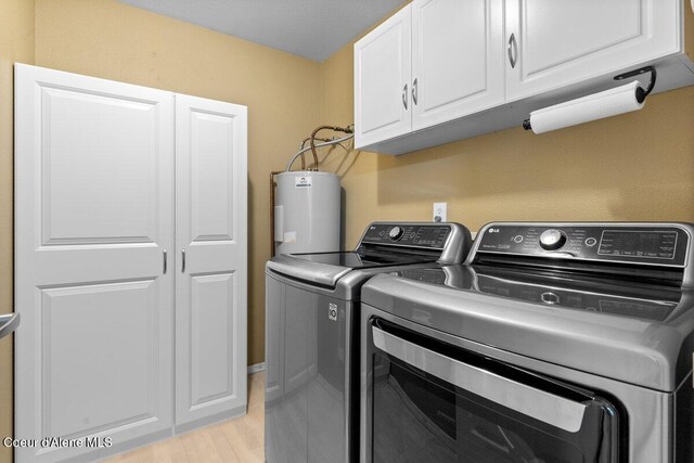 31716 N Middle Ave, Spirit Lake, ID 83869 - laundry area with water heater, cabinet space, washing machine and clothes dryer, and light wood finished floors