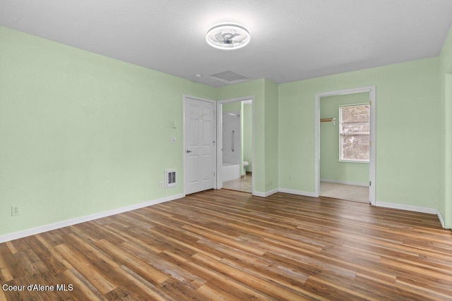 31716 N Middle Ave, Spirit Lake, ID 83869 - unfurnished bedroom featuring baseboards, wood finished floors, a spacious closet, and a closet