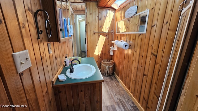 33671 N Macdonalds Unit 2Nd, Dock, Bayview, ID 83803 - half bath with wooden walls, wood finished floors, vanity, and baseboards