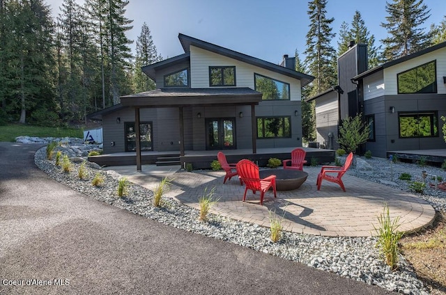 74 Wedge Ct, Priest Lake, ID 83856 - rear view of property with a fire pit, a patio, french doors, and a chimney
