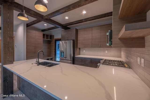 74 Wedge Ct, Priest Lake, ID 83856 - kitchen featuring high end refrigerator, a sink, backsplash, light stone counters, and beamed ceiling